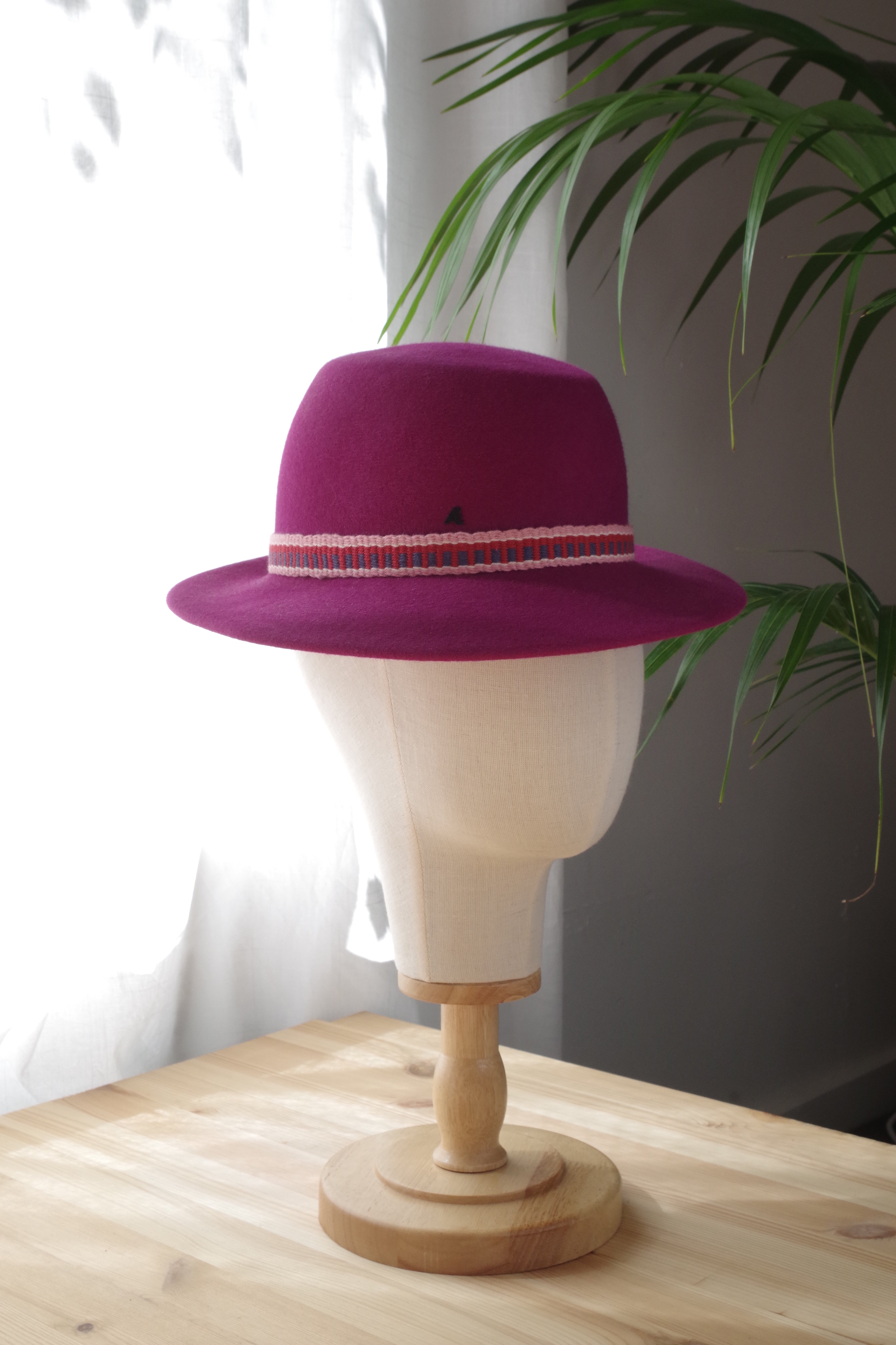 Side view of handcrafted plum fur felt trilby hat with a handwoven ribbon by MICHAETT