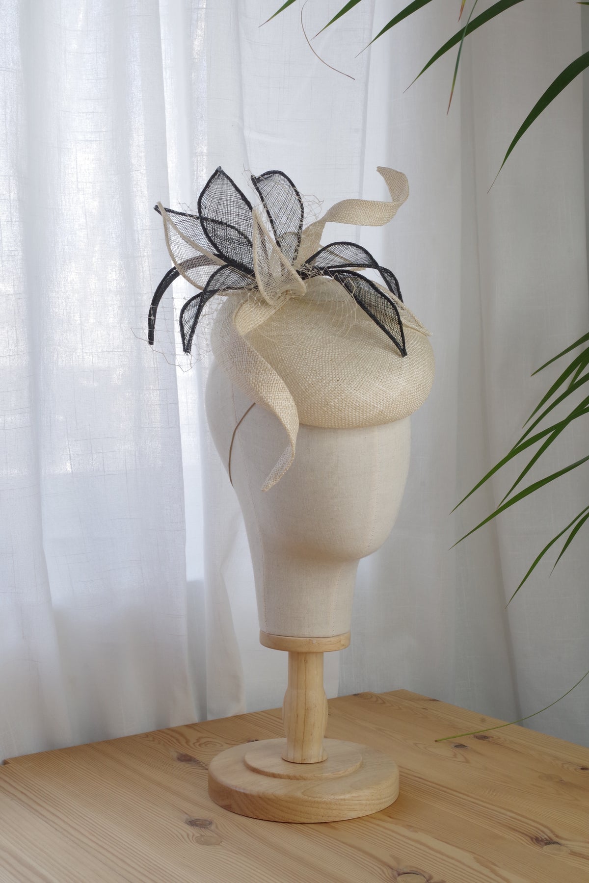 Side view of cream parasaisal straw cocktail hat with sculptural sinamay leaves by MICHAETT