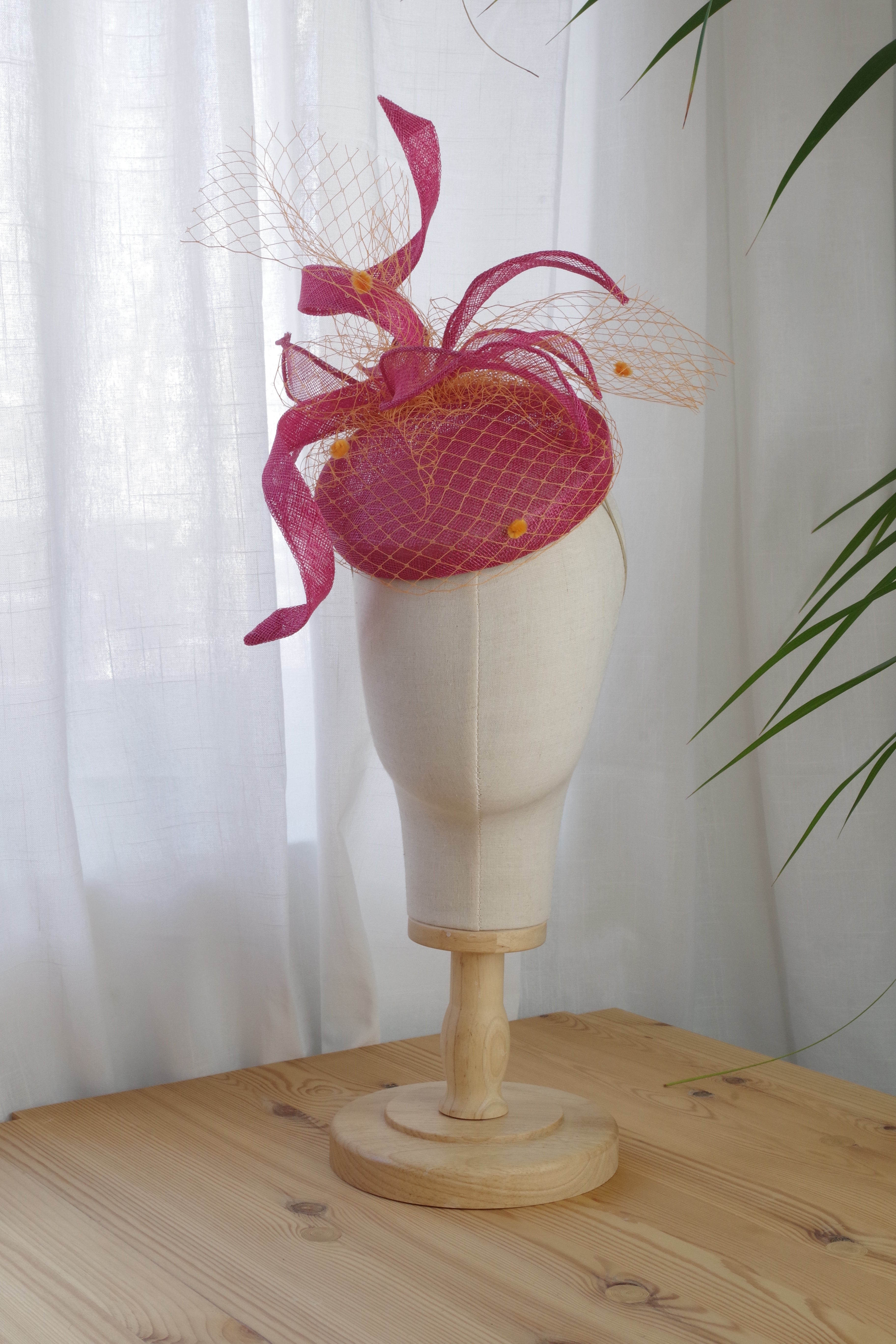 Pink sinamay cocktail hat with orange veiling and sculptural loops for Spring Racing Carnival by MICHAETT