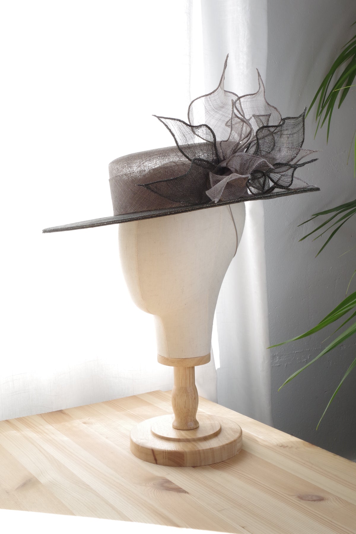 Side view of grey occasion hat with sculptural sinamay loops by MICHAETT