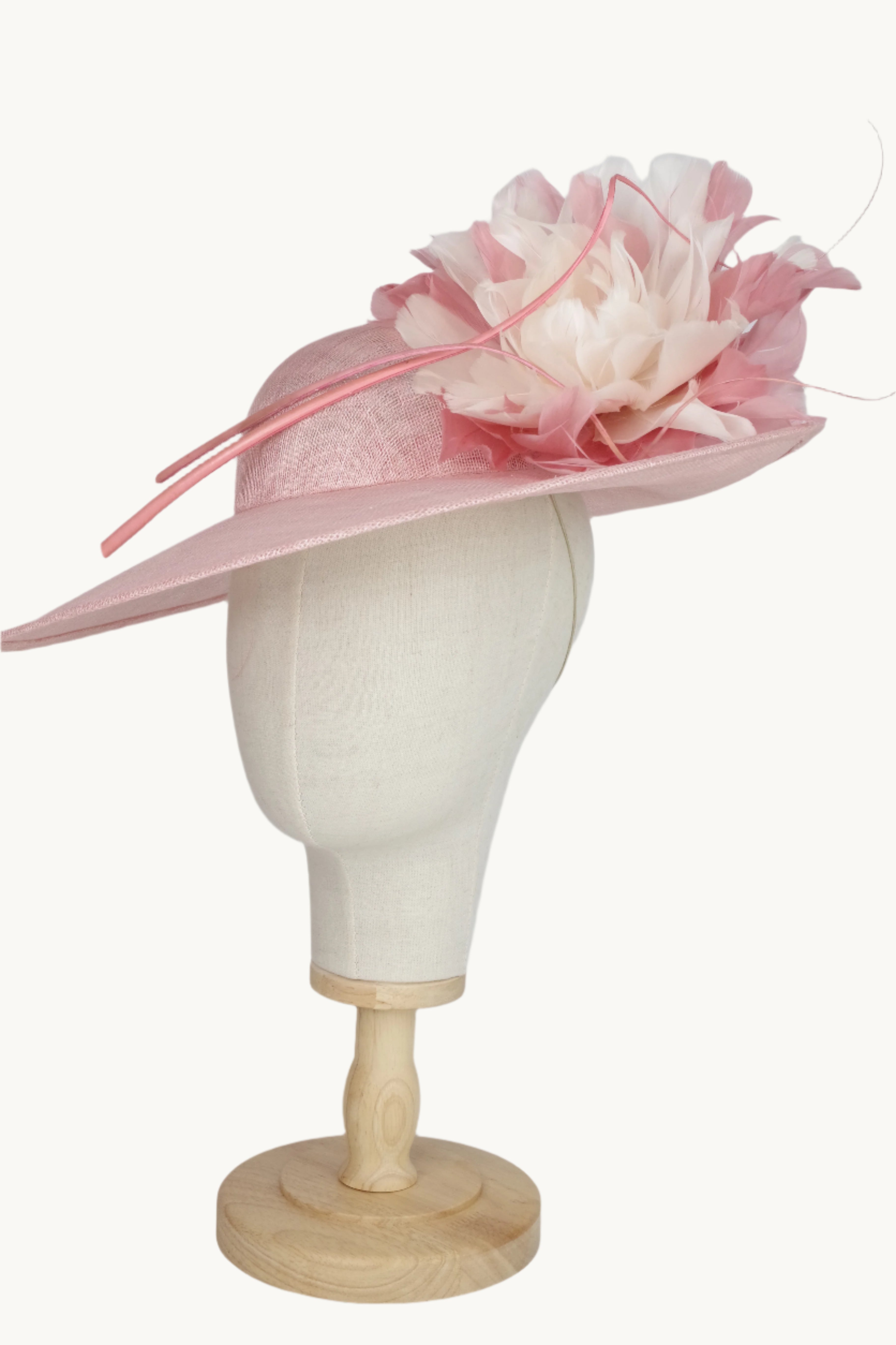 Pink decorative hat on a mannequin head against a white background