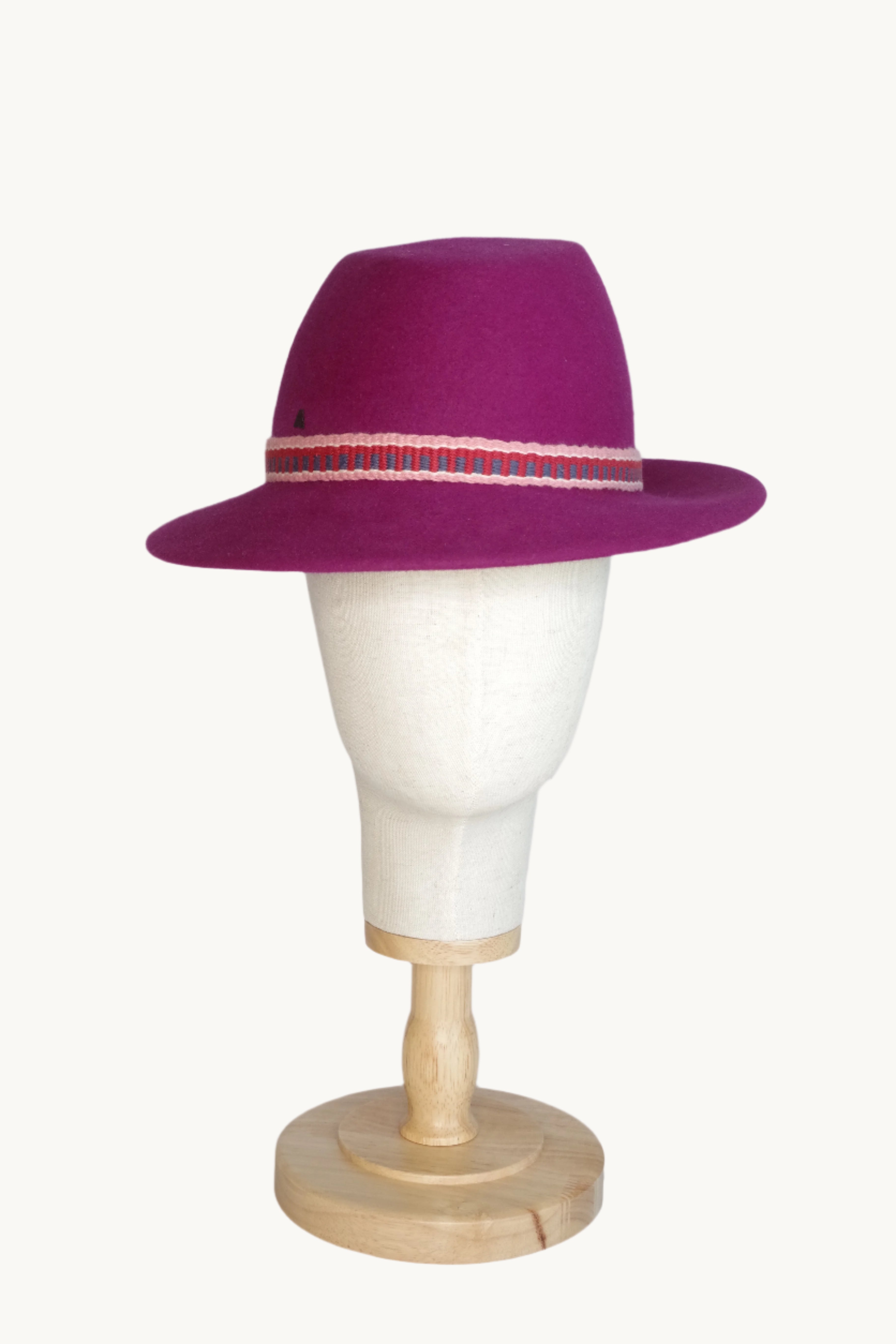 Decorative wall sconce with a purple shade and wooden base on a white background