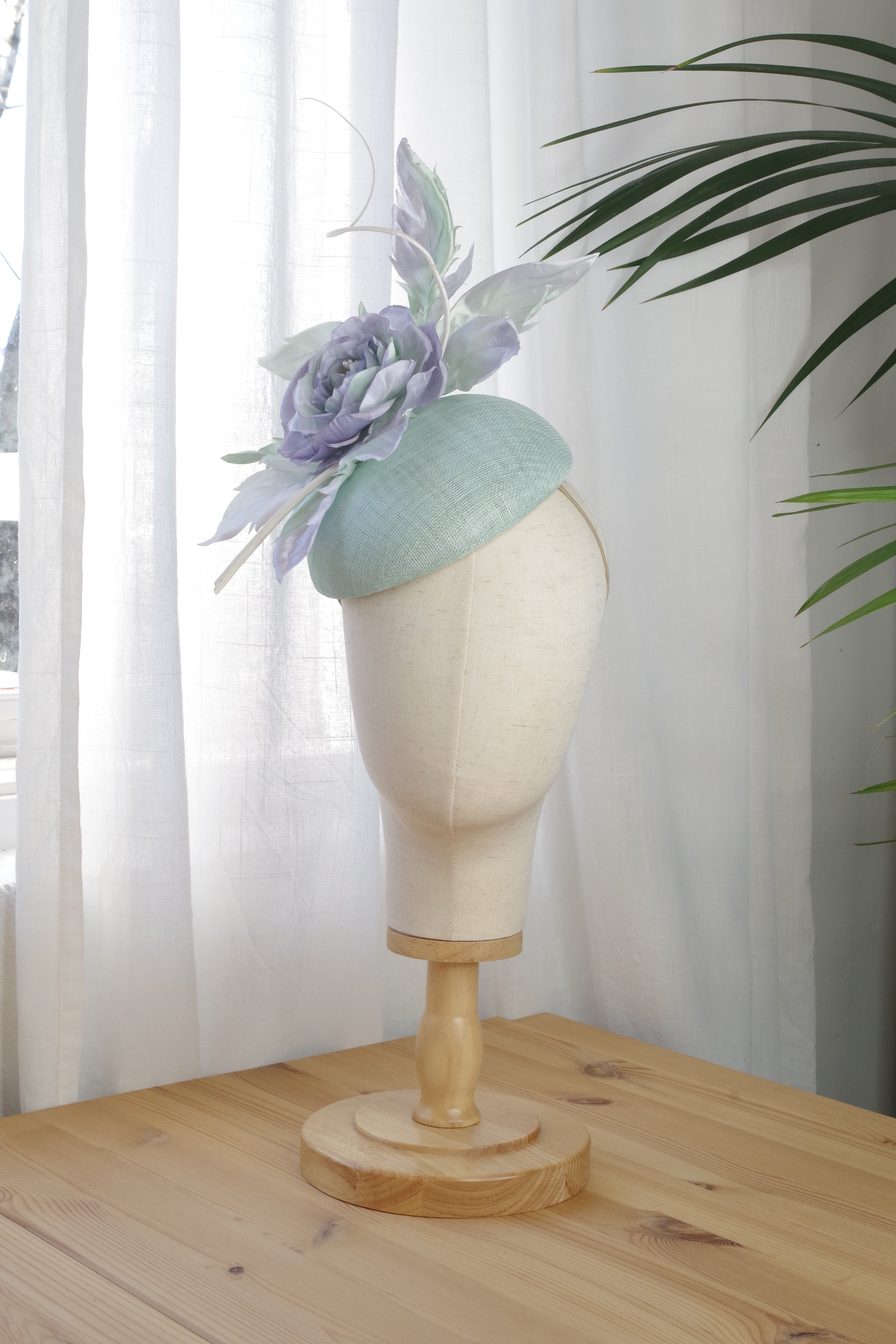 Handcrafted mint sinamay cocktail hat by MICHAETT featuring a handmade satin silk flower a delicate silk leaves.