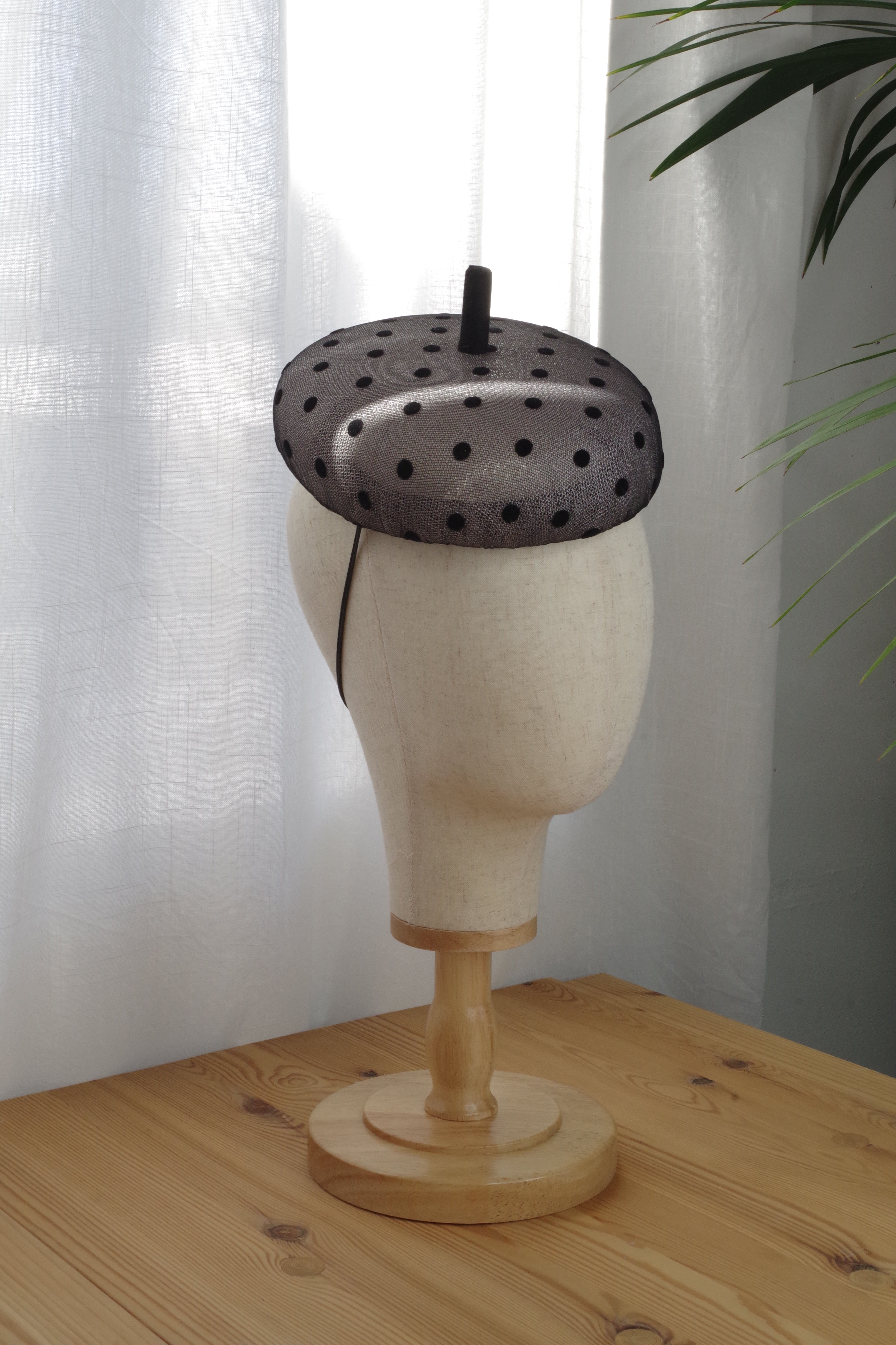 Side view of light-grey sinamay cocktail hat with black dotted veil by MICHAETT
