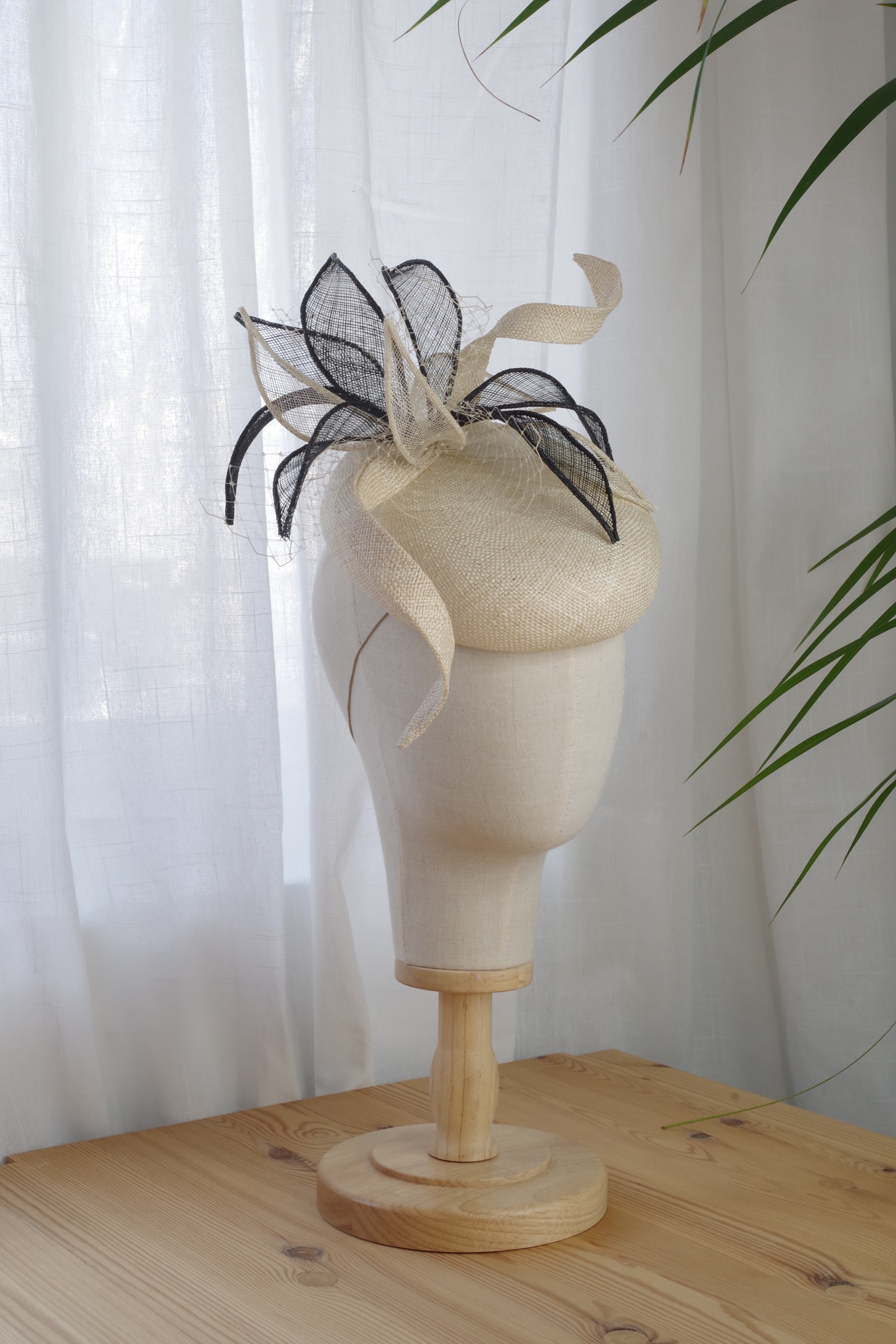 Side view of cream parasaisal straw cocktail hat with sculptural sinamay leaves by MICHAETT